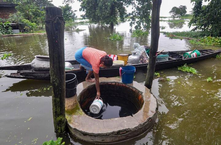 असम के कामरूप जिले से ये अनोखी तस्वीर आई है जिसमें एक महिला बाढ़ग्रस्त इलाके में पीने के पानी के लिए कुएं से पानी खींच रही है.