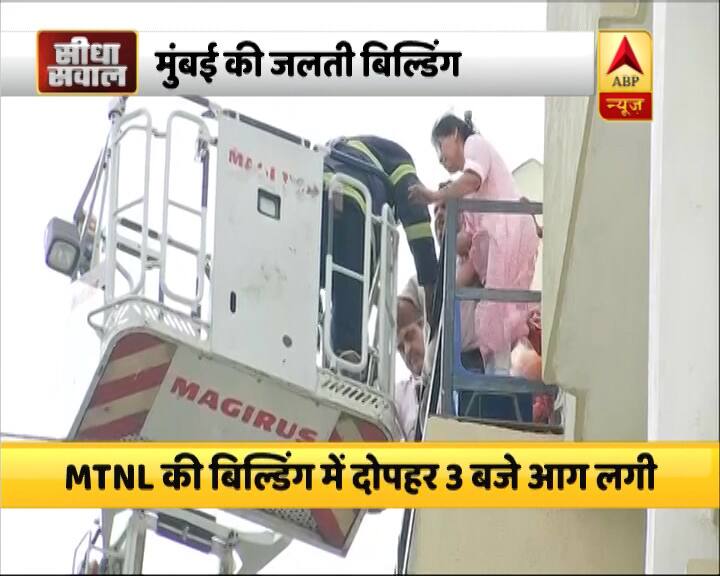 एक महिला को दमकलकर्मी मुंबई की जलती बिल्डिंग से लैडर के जरिए बाहर निकाल रहे हैं.
