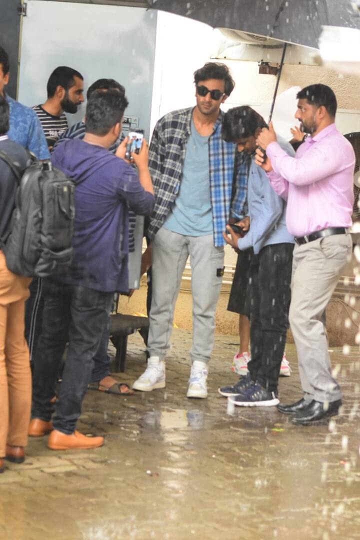 हालांकि इस दौरान रणबीर के एक सहयोगी ने उन्हें बारिश में भीगने से बचाने के लिए छाता लगाए रखा. (तस्वीर: मानव मंगालनी)