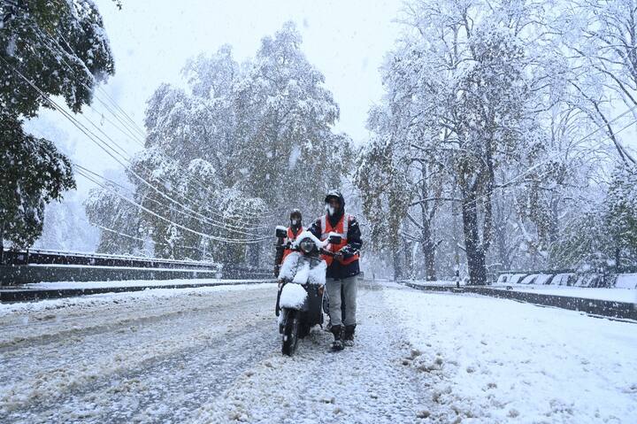 श्रीनगर की सड़कों पर जमी बर्फ और फंसे वाहनों को हटाने नगर निगम कर्मचारी जुट गए हैं.