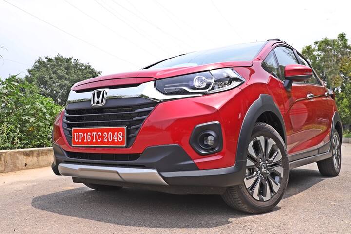 नई WR-V केवल 4 मीटर के अंदर आती है लेकिन बड़ी लगती है और कई एसयूवी और हैचबैक से बेहतर लगती है. इसका शेप एक क्रॉसओवर की तरह होता है और लेकिन जैज़ कार जिस पर ये आधारित है से इसका अलग फेस है और यही कारण है कि WR-V यहां अच्छा स्कोर करती है. ये लंबी है, चौड़ी है और पर्याप्त बड़ी लगती है जो इसकी प्रेसेंस के लिए जरूरी है. WR-V में नया पार्ट इसकी सबसे खास बात फ्रंट में नजर आती है जिसमें ग्रिल हैं जिसमें अब और ज्यादा क्रोम है और ये फिर इसकी प्रेसेंस को और शानदार बनाती है. इसमें एक सॉलिड क्रोम स्लैब है और बड़ा सा होंडा का लोगो है जो कि अब नए एलईडी प्रोजेक्टर हैडलैंप्स से जुड़ा है और एलईडी फॉगलैंप्स भी हैं. इसके साथ ही आप इसके हैडलैंप्स में कुछ ब्लैकएंड एलिमेंट्स भी पाएंगे.
