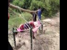 मध्य प्रदेशः गांव में सड़क नहीं होने के कारण बीमार महिला को खाट पर बैठाकर अस्पताल ले गए परिजन