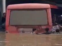 गुजरात: राजकोट में पानी से भरे अंडरपास में फंसी बस, JCB से खींच के निकाला गया बाहर