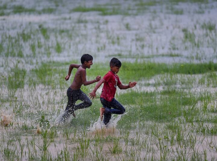 राजधानी दिल्ली में बारिश का लुफ्त उठाते दो बच्चे.