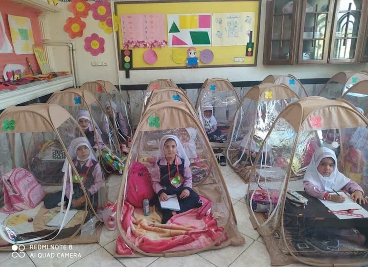 iran reopens schools after corona havoc with strict rule students sitting inside transparent tents Viral: ईरान में कोरोना के दौर में जब स्कूल खुले तो देखें कैसे पढ़ रहे हैं बच्चे, वायरल हुई तस्वीर