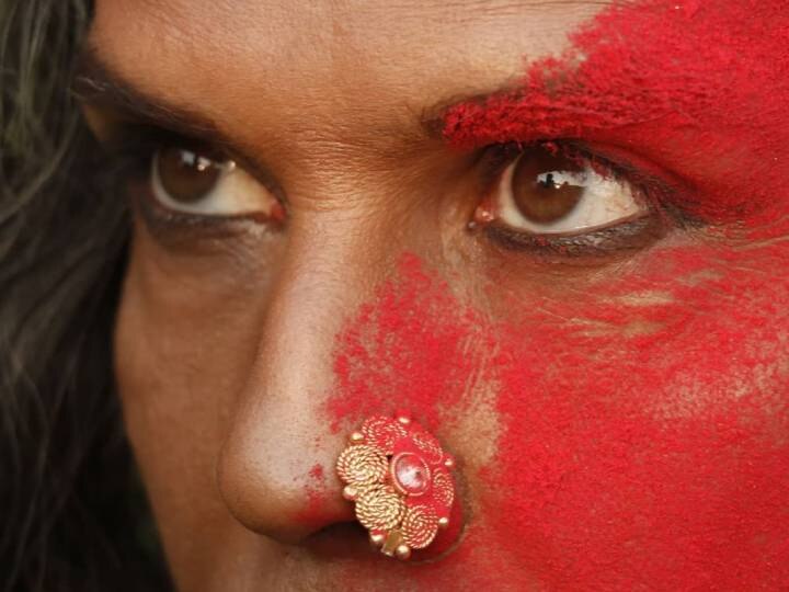 Milind Soman photo with kajal and nose ring viral on social media मिलिंद सोमन ने आंखों में लगाया काजल और पहनी नोजरिंग, आधे चेहरे पर लगा लाल गुलाल, तस्वीर वायरल