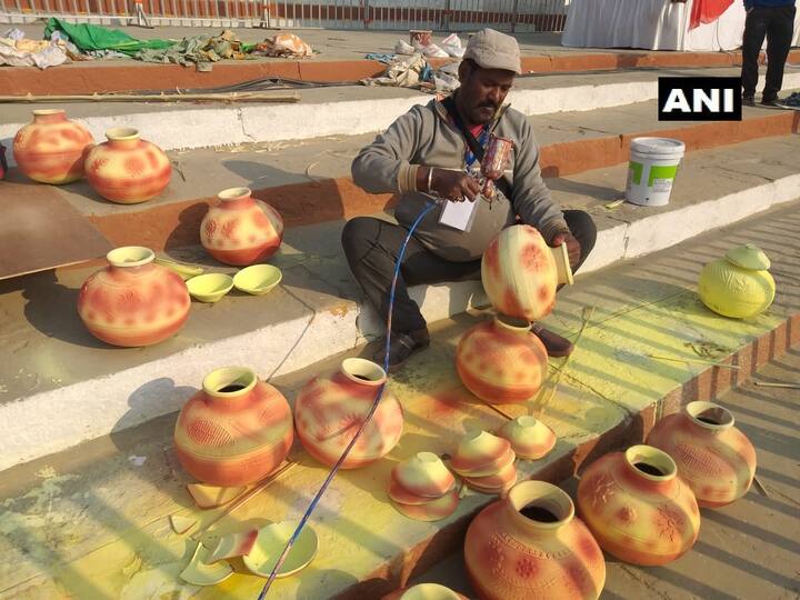 घाट पर सजाये जाने वाले मटकों पर पेंट करता कारीगर.