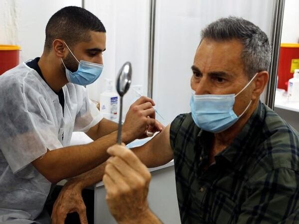 Yuri Geller introduced the Corona vaccine in this special way Viral Video: इज़राइल में वैक्सीन लगवा रहा था जादूगर, बैठे-बैठे देखते ही देखते मोड़ दी चम्मच
