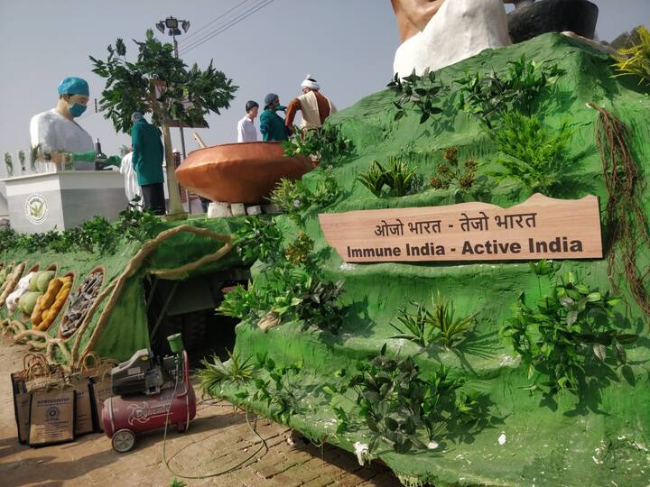 आयुष मंत्रालय की झांकी- चरक संहिता से घिरे आचार्य चरक को दिखाया गया है जिनके आसपास विभिन्न तरह के औषधीय पौधे दिखाई दे रहे हैं. औषधीय पौधा गिलोय झांकी में कई जगह दिखाई दिया है साथ ही आयुष काढ़ा और चवनप्राश रोग प्रतिरोधक क्षमता बढ़ाने के लिए प्रदर्शित किया गया है. झांकी के बीच वाले हिस्से में अशोक का पेड़ और उसके लाभों को दिखाया गया है.