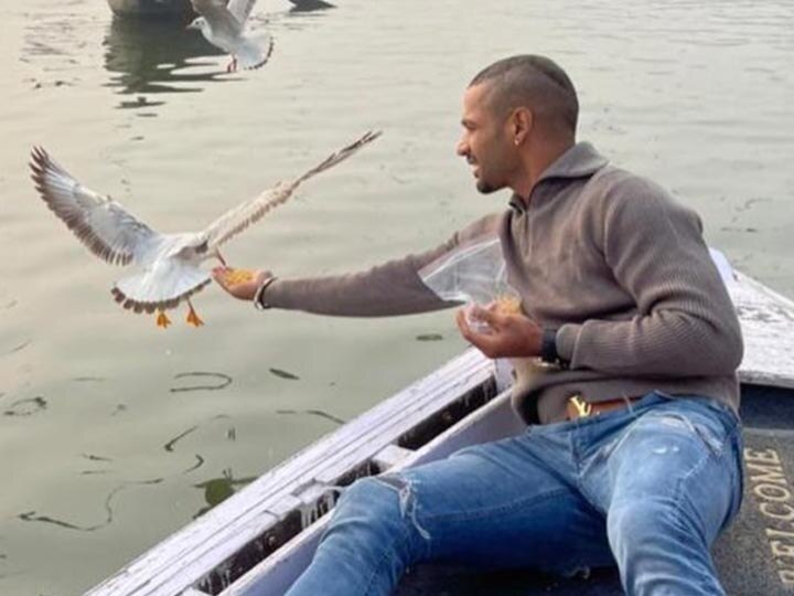 Shikhar Dhawan shares photos of feeding birds amid bird flu in varanasi action taken against boatman वाराणसी: शिखर धवन के पक्षियों को दाना खिलाने पर विवाद, प्रशासन ने किया नाविक का चालान