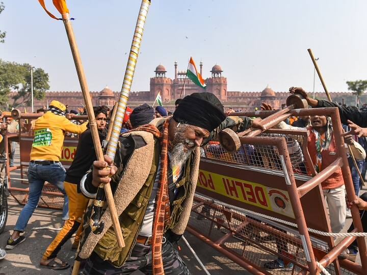तस्वीर में साफ तौर पर देखा जा सकता है कि किस तरह से आंदोलनकारी किसान लाल किले के पास लगी बैरिकेड को गिरा रहे हैं. किसान नारेबाजी कर रहे थे और उनके हाथों में झंडा था.