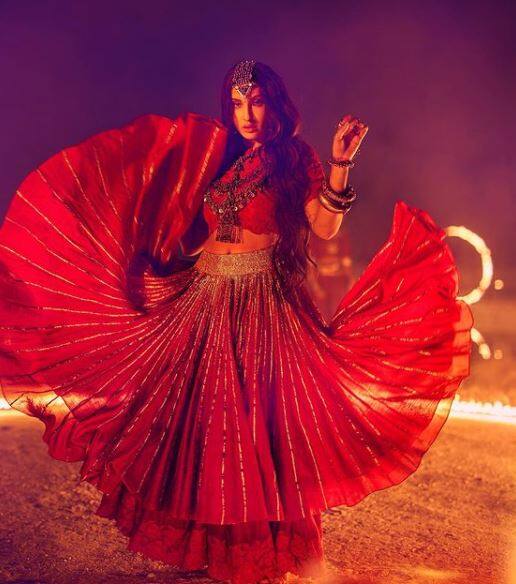 एक और तस्वीर नोरा ने शेयर की जिसमें उन्होंने लाल रंग की एथनिक ड्रेस पहनी हुई है. ये तस्वीर उनके एक गाने की शूटिंग की है. उनके फैंस ने इस लुक की बेहद तारीफ की.