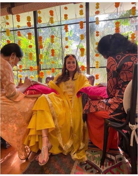 एक्ट्रेस दिया मिर्जा ने बॉयफ्रेंड वैभव रेखी के साथ शादी कर लगी. 15 फरवरी को इस कपल ने सात फेरे लिए. शादी से पहले अपने हाथों में मेंहदी लगवाती दिया बेहद खुश नजर आ रहीं है. अपने मेंहदी फंग्शन में दिया ने yellow dress के साथ flower jewellery कैरी की थी. 