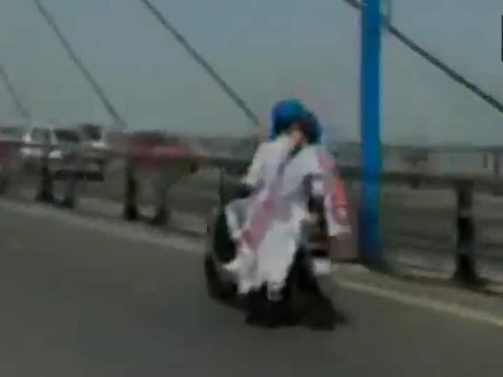 ममता बनर्जी ने बढ़ती तेल कीमतों के विरोध में निकाली ई-बाइक रैली, गले में लटकाया पोस्टर, देखें वीडियो West Bengal CM Mamata Banerjee travels on Electric scooter in Kolkata against rising fuel prices ममता बनर्जी ने बढ़ती तेल कीमतों के विरोध में निकाली ई-बाइक रैली, गले में लटकाया पोस्टर, देखें वीडियो