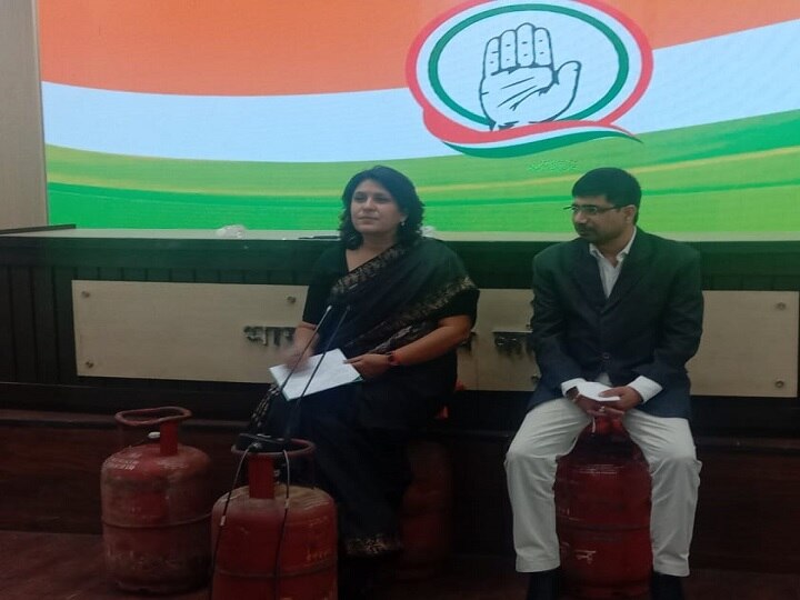 Delhi Congress leader sit on gas cylinders attacks on pm modi over fuel prices hike रसोई गैस की बढ़ी कीमतों का कांग्रेस ने किया विरोध, LPG सिलेंडर पर बैठकर किया प्रेस कॉन्फ्रेंस