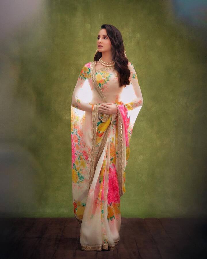 अब ज़रा इस साड़ी को ही देख लीजिए. प्रिंटेड डिज़ाइन की ये साड़ी जितनी सिंपल है उतनी ही खूबसूरत भी है लेकिन नोरा के पहनने के बाद इसकी खूबसूरती और भी बढ़ गई है. अक्सर एक्ट्रेसेस इस तरह पल्लू पकड़ना पसंद नहीं करती लेकिन नोरा ने पूरे इंडियन स्टाइल से इस साड़ी को कैरी किया है.  (Photo Credit - Instagram)