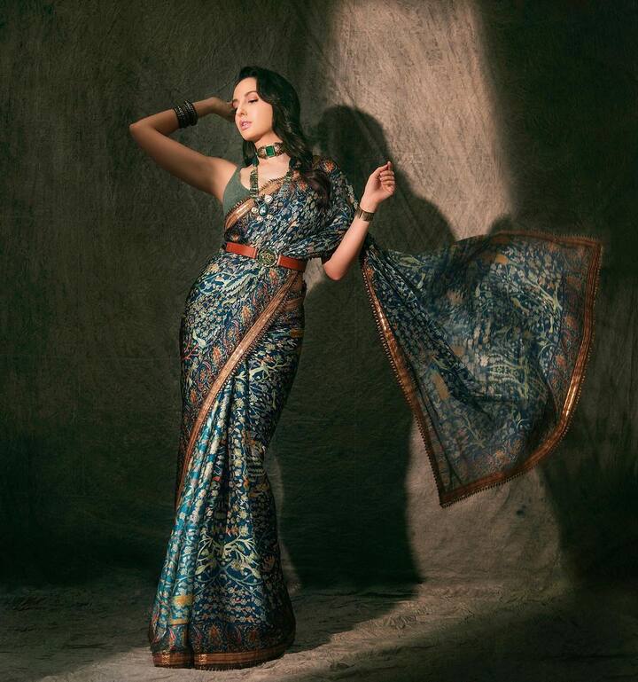 ठीक इसी तरह इस साड़ी को भी देख लीजिए. सिंपल प्रिंटेड साड़ी लेकिन उसके साथ नोरा फतेही ने कमर पर बेल्ट बांधी और साडी को बना दिया एक दम डिफरेंट.  (Photo Credit - Instagram)