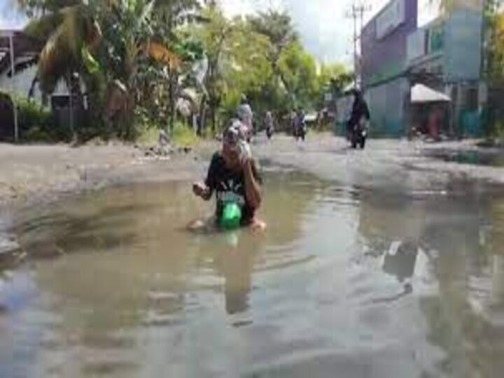 Indonesia: A man taught officers a lesson on broken road, video goes viral आखिर यह शख्स बीच सड़क पर गड्ढे में बैठकर क्यों नहाने लगा ? वजह जानकर आप भी कहेंगे- वाह!