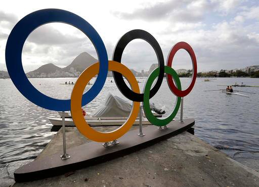 Athletes warm up during rowing team practices near the Olympic rings in Lagoa ahead of the 2016 Summer Olympics in Rio de Janeiro, Brazil, Wednesday, Aug. 3, 2016. (AP Photo/Matt York)