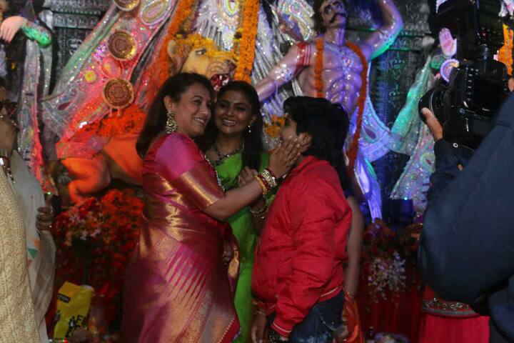 একটি শিশুকে আদর করছেন রানি