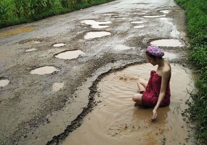 Fed Up Thai Woman Takes A Dip In A Pothole To Protest At The Poor Condition Of Her Hometowns Roads ভিডিওতে দেখুন: রাস্তার বেহাল দশা, প্রতিবাদে গর্তে বসে স্নান তাই মডেল-এর
