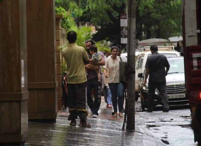 রাস্তা বৃষ্টিতে ভেজা। সাবধানে ছেলেকে নিয়ে চলেছেন বাবা।