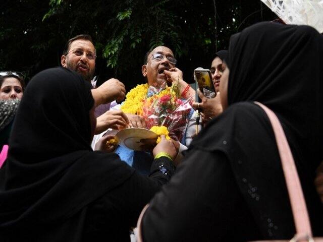 বিজেপি নেতা বিজয় গোয়েলকে মিষ্টিমুখ। ছবি: সাজ্জাদ হুসেন, এএফপি। 