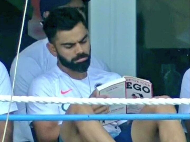 Virat Kohli Reading 'Detox Your Ego' In Dressing Room Sends Twitter into Frenzy অহং ঝেড়ে ফেলার পাঠ নিচ্ছেন বিরাট কোহলি! ড্রেসিংরুমে হাতে বই দেখে জল্পনা ক্রিকেটপ্রেমীদের