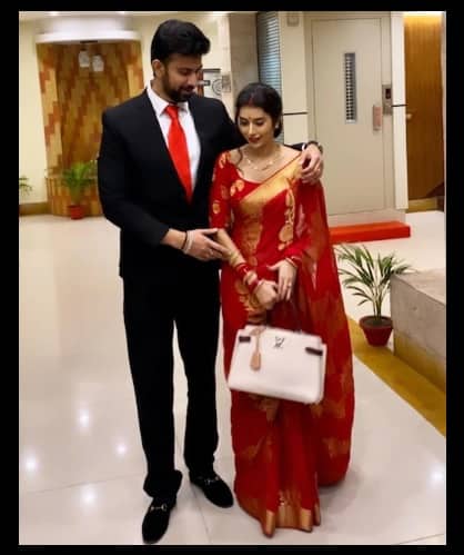 লাল শাড়িতে বাঙালি বধূর বেশে বেশ মানিয়েছিল চারুকে। কালো কোট পড়েছিলেন রাজীব।
