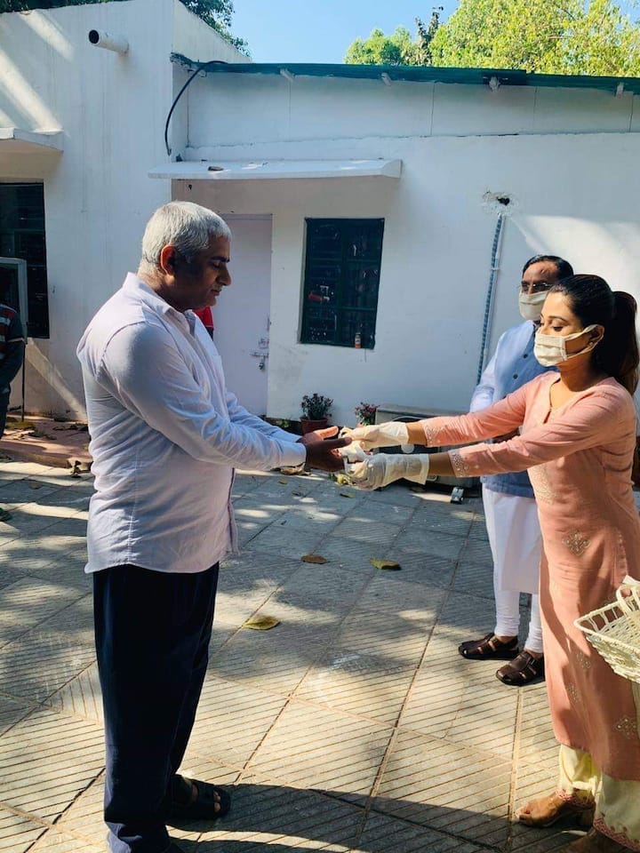 মাস্কগুলি নিজের হাতে যাদের প্রয়োজন তাঁদের হাতে তুলে দিচ্ছেন আরুশি।