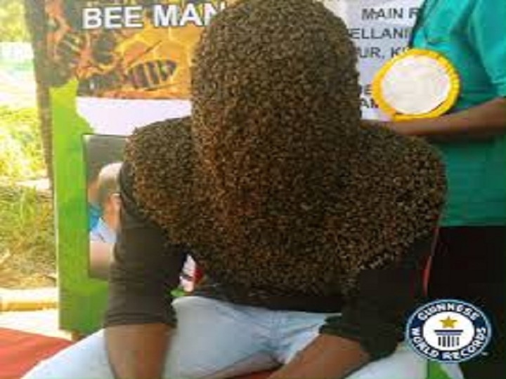 This person kept pasting 60 thousand honey bees for four hours made a world record মাথা-মুখ ঢেকে হাজার হাজার মৌমাছি, চার ঘন্টার বেশি সময় কাটিয়ে গিনেস বুকে রেকর্ড কেরলের যুবকের