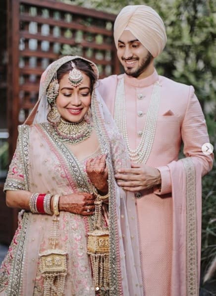 নেহার বিয়ের হালকা পিচ রঙের লেহঙ্গাটিকে অনেকেই বলেছেন, সেটি অনুষ্কা শর্মার বিয়ের লেহঙ্গার অনুকরণ। অনুষ্কার সেই লেহঙ্গাও ছিল সব্যসাচী চক্রবর্তীর ডিজাইন করা।
