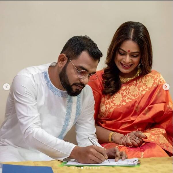 সেইদিন আগুনরঙা দক্ষিণী শাড়িতে ঝলমল করছিলেন ইমন চক্রবর্তী। পাশে মানানসই সাদা সাবেকি পোশাকে মিউজিশিয়ান নীলাঞ্জন ঘোষ। ছুটির দিনেই ঘরোয়া অনুষ্ঠানে গাঁটছড়া বেঁধেছিলেন এই জুটি।
