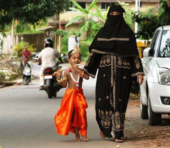 या फोटोमध्ये एक मुस्लीम बुरखाधारी महिला आपल्या बालगोपाळाला घेऊन जाताना..