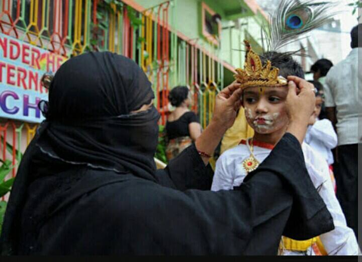 एक मुस्लीम आई आपल्या कन्हैयाच्या मोरपीसाला नीट करताना दिसत आहे.