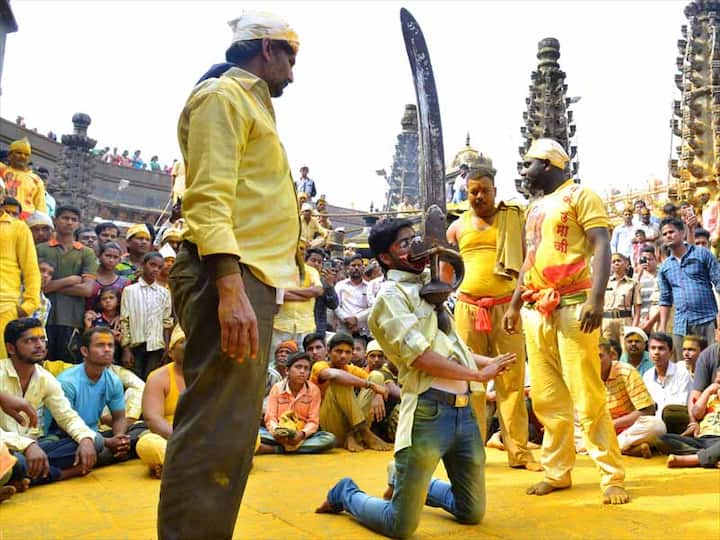 तब्बल 42 किलोंची तलवार दाताने उचलताना भाविक (फोटो : विजयकुमार हरिश्चंद्रे)