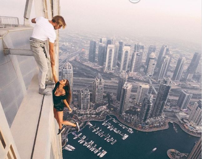 Russian Model Dangles From Cayan Tower In Dubai 306 मीटर उंचीच्या इमारतीला लटकून मॉडेलचं फोटोशूट
