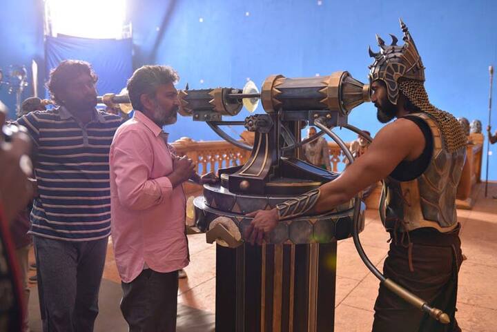 हा सीन तुमच्या लक्षात असेल. भल्लाल देव पहिल्यांदा देवसेना आणि बाहुबली यांना दुर्बिणीतून पाहतो, त्यावेळी भल्लाल देवच्या मुलाचं शीर त्यांच्या हातात असतं. तोच सीन समजावून सांगताना दिग्दर्शक राजमौली. (Photo: Arka Mediaworks) 