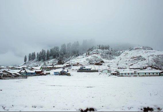  परिसरातील घरे, डोंगरावर बर्फांची सफेद चादर दिसत आहेत. 