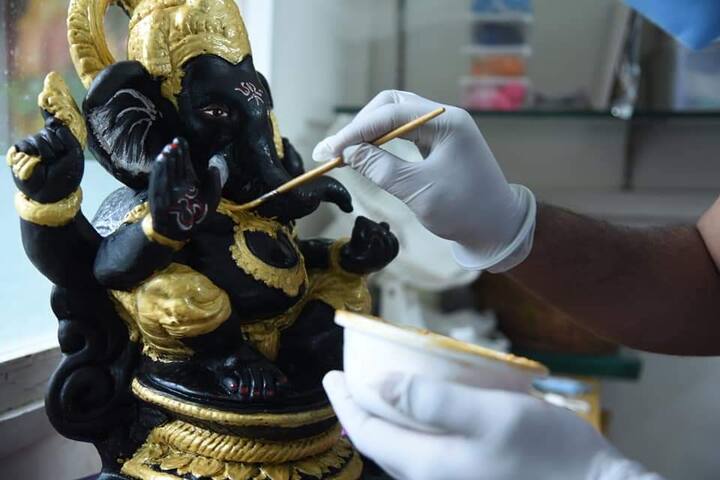 चॉकलेटच्या गणपतीवर शेवटचा हात फिरवताना कर्मचारी