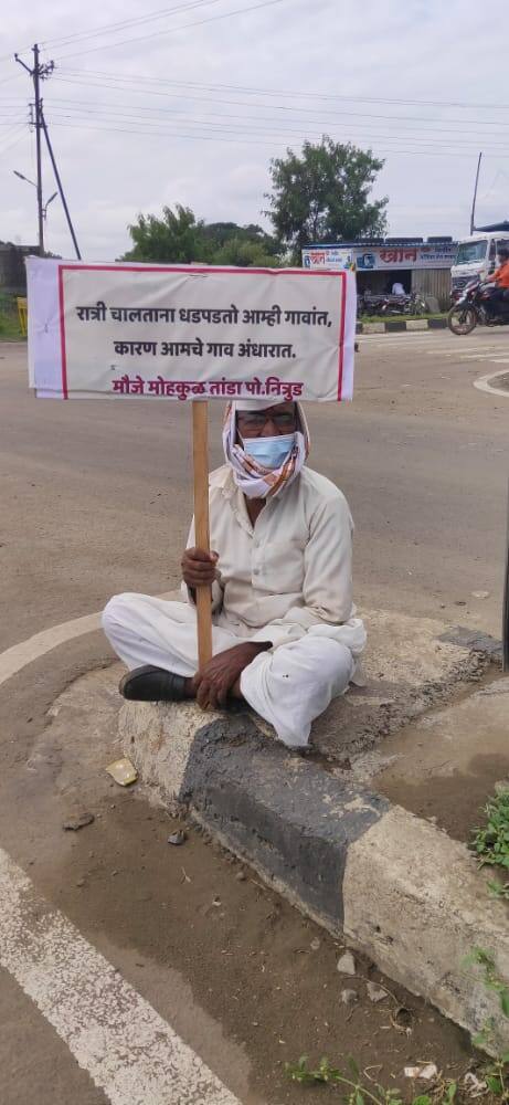 गावकरी मागण्यांचं फलक घेऊन रस्त्यावर बसले आहेत