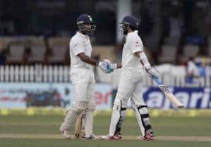 India's Cheteshwar Pujara, right, shakes hand with Murali Vijay after Vijay made half century against New Zealand during their first test match in Kanpur, India , Thursday, Sept. 22, 2016. (AP Photo/ Tsering Topgyal)