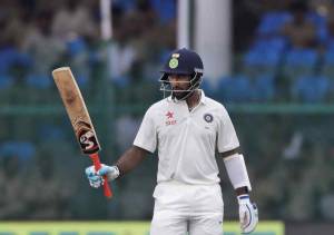 India's Cheteshwar Pujara raises his bats after making half century against New Zealand during their first test match in Kanpur, India , Thursday, Sept. 22, 2016. (AP Photo/ Tsering Topgyal)