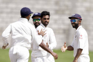 India's bowler Bhuvneshwar Kumar, second from right, is congratulated by Ajinkya Rahane, right, and teammates after taking the wicket of West Indies' Shane Dorwich during day four of their third cricket Test match at the Daren Sammy Cricket Ground in Gros Islet, St. Lucia, Friday, Aug. 12, 2016. (AP Photo/Ricardo Mazalan)