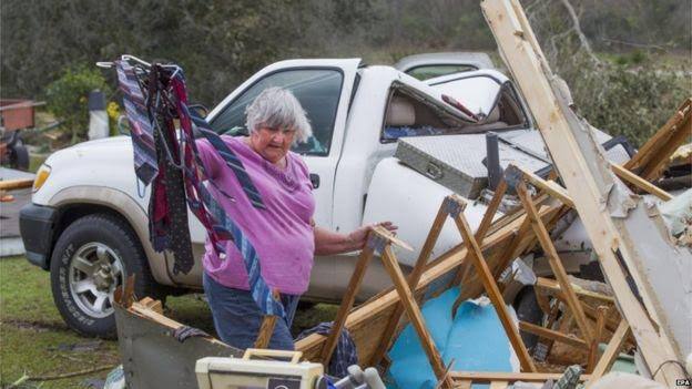 ਆਪਣੇ ਸਮਾਨ ਨੂੰ ਸੰਭਾਲਦੀ ਹੋਈ ਇਕ ਮਹਿਲਾ।