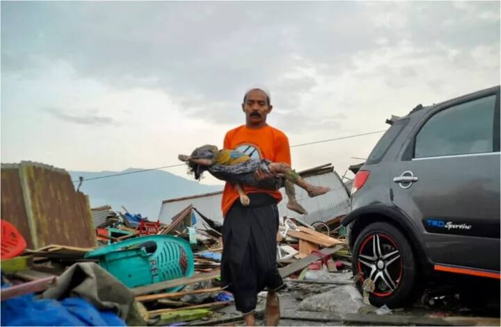 ਤਸਵੀਰ 'ਚ ਇਕ ਵਿਅਕਤੀ ਛੋਟੇ ਬੱਚੇ ਦੀ ਲਾਸ਼ ਨਾਲ ਦਿਖਾਈ ਦੇ ਰਿਹਾ ਹੈ।