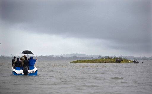 Forest officials patrol in a speed boat as One horned Rhinos take shelter on higher ground of a flooded Kaziranga national park in Kaziranga, 250 kilometers (156 miles) east of Gauhati, India, Monday, July 10, 2017. Police are patrolling for poachers as rhinoceros, deer and buffalo move to higher ground to escape floods inundating an Indian preserve. Kaziranga National Park has the world's largest population of the one-horned rhinoceros and is home to many other wildlife. (AP Photo/ Anupam Nath)