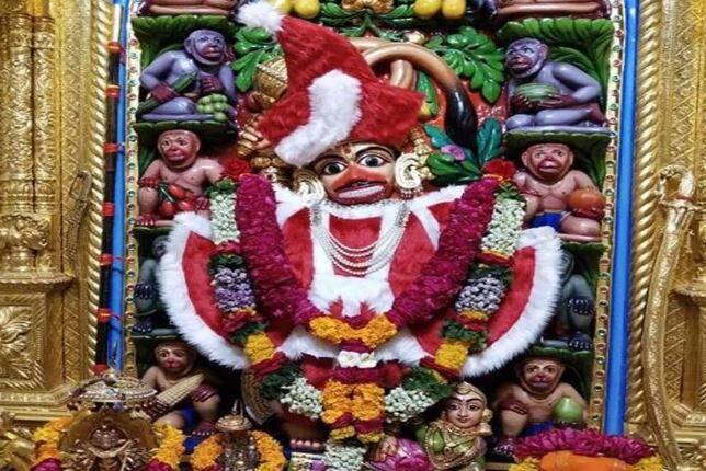 બોટાદ: ગુજરાતમાં સારંગપુર ખાતે હનુમાનજીને સાંતાક્લોઝ જેવા કપડા પહેરાવવામાં આવતા વિવાદ થયો છે. આ ઘટના બાદ હિન્દુ સંગઠનોમાં ભારે નારાજગી ફેલાઈ હતી. વિવાદ વધતા આ પ્રકારના કપડા ઉતારી લેવામાં આવ્યાં હતાં. સાળંગપુર મંદિરના કોઠારી વિવેકસાગર સ્વામીએ જણાવ્યું કે આ ગરમ વાઘા શિયાળામાં ભગવાનને અર્પણ કરવામાં આવતા હોય છે. અત્યારે ધર્નુમાસ ચાલી રહ્યો છે. ધનુર્માસ નિમિત્તે ઠાકોરજી સવારે વહેલાં ભણવાં જતા હોય છે. એટલે દરરોજ અલગ-અલગ કલરના વાઘા પહેરાવવામાં આવે છે. આજે રવિવારનો દિવસ છે. ભગવાનને એવો ભાવ વ્યક્ત કર્યો છે કે ભગવાનને આજે ગરમ વાઘા પહેરાવી અને તેમના બાળ સખા મિત્રો સાથે રમવા માટે મોકલીએ.