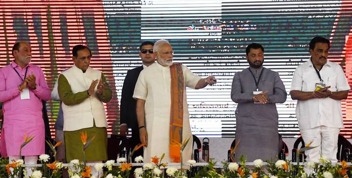 સુરતઃ વડાપ્રધાન નરેન્દ્ર મોદી આજે એક દિવસના ગુજરાત પ્રવાસે છે. દાંડી રવાના થતાં પહેલા વડાપ્રધાન મોદીએ સુરતમાં એરપોર્ટના નવા ટર્મિનલનું ખાતમુહૂર્ત કર્યું હતું. આ દરમિયાન તેમણે એક જનસભાને સંબોધન કર્યું. પીએ મોદી જે સમયે ભાષણ આપતા હતા તે દરમિયાન કવરેજ કરી રહેલો એક કેમેરામેન સ્ટેન્ડ પરથી નીચે પડી ગયો હતો. કેમેરામેનને પડતો જોયા બાદ તેની મદદ માટે લોકો દોડી આવ્યા હતા. 