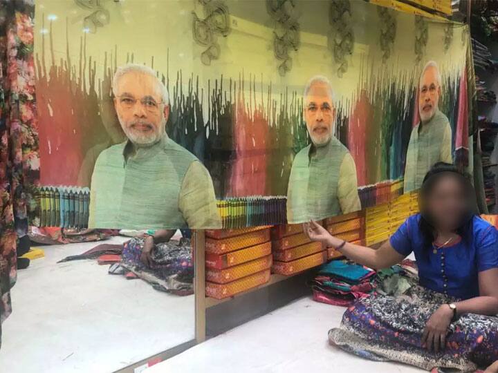 PM મોદીની પ્રિન્ટવાળી સાડી તૈયાર કરવાનું ગુજરાતના વેપારીને ભારે પડ્યું? જાણો કેમ The Gujarat businessman has been hard to get PM Modi's printed sarees PM મોદીની પ્રિન્ટવાળી સાડી તૈયાર કરવાનું ગુજરાતના વેપારીને ભારે પડ્યું? જાણો કેમ